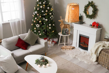 Interior of festive living room with Christmas tree, fireplace and sofa