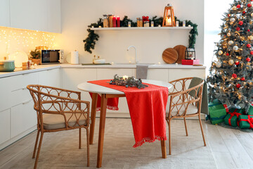 Interior of kitchen with counters, dining table and Christmas tree