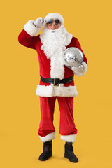 Cool Santa Claus with disco ball on yellow background