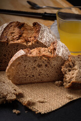 Dark rye sourdough bread sliced on black background