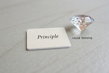 Inspirational message card with the word 'Principle' and a diamond on a wooden surface, symbolizing strength