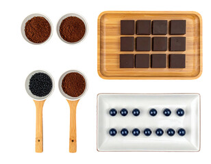 Overhead shot espresso powder, chocolate squares, berries, and wooden spoons
