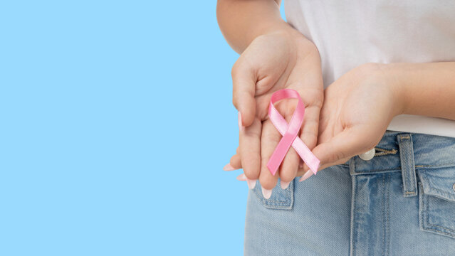 Person supporting cancer awareness with a pink ribbon