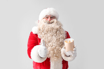 Santa Claus with tasty french fries showing thumb-up on white background