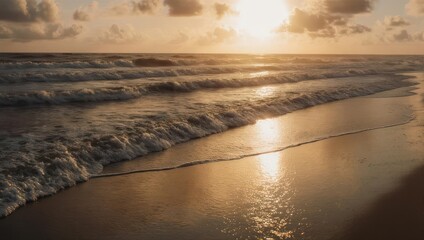Golden sunrise over a tranquil beach. Waves gently wash the sandy shore, reflecting the warm light of dawn