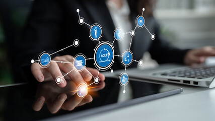 A business professional interacts with digital concepts of agile workflows on a tablet, showcasing modern technology in a contemporary office setting. Tessel