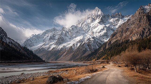 Snowy mountain range, winding path, autumnal landscape
