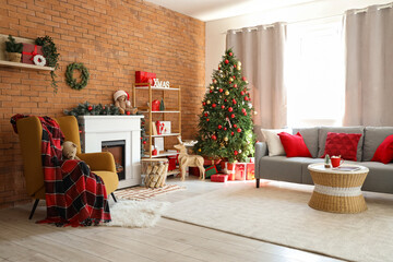 Interior of living room with fireplace, armchair and Christmas tree