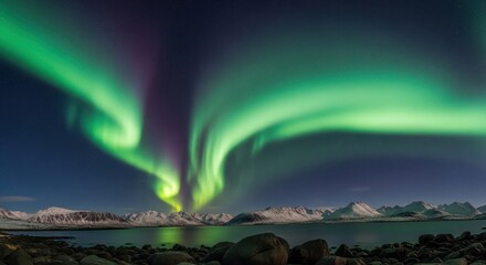 Swirling curtains of vibrant green aurora borealis light up a star-filled sky above a tranquil, snowy mountain landscape at night
