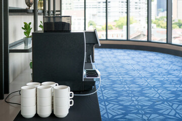 Hotel convention center hallway with coffee maker and cups. 