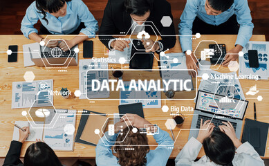A diverse group of professionals collaboratively analyzing data, utilizing technology and charts for insights during a productive meeting in a modern office setting. Amity