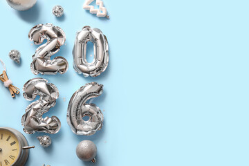 Figure 2025 made of foil balloons with Christmas decorations and alarm clock on blue background