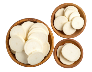 Overhead view of three wooden bowls filled with sliced white root vegetables
