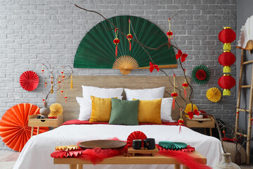 Interior of bedroom with bed, tables and decor for Chinese New Year celebration