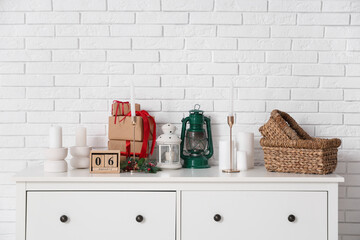 Christmas decorations and green lantern near white brick wall, closeup