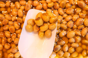 Grilled ginkgo nuts served in a warm broth at a market