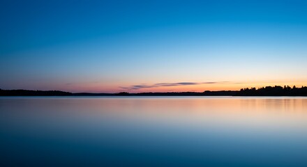 Naklejka premium Serene waterscape at dusk reflecting the colorful sky with minimalist composition