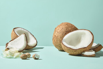 Simple coconut halves and shea butter chunks styled with raw shea butter nuts, clean composition on pastel background for use in product design, ads, and packaging visuals.