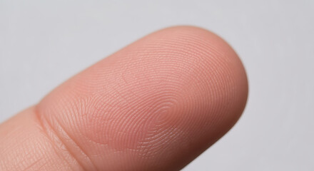 Detailed macro view of an individual's unique human fingerprint, highlighting intricate skin texture and epidermal ridges for concepts of identity verification, cybersecurity, biometric authentication