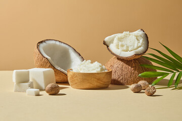 Clean tropical composition with coconut halves, creamy shea butter, and nuts styled on beige background, used for cosmetic ingredient ads and organic skincare.