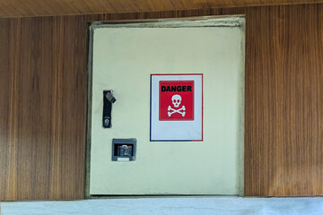 Danger warning sign on a utility box or cabinet, indicating a potential hazard