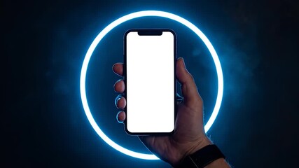 A hand holds a smartphone with a blank screen in front of a glowing blue neon ring on a dark background. - Powered by Adobe