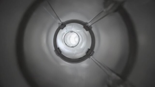 Abstract long tunnel with bright light at the end moving forward. Perspective view of a white pipe with a reflective surface. Dynamic motion footage.