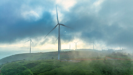 Aerial view of Wind turbines amidst misty landscape at sunset in Da lat, Vietnam