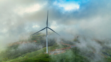 Aerial view of Wind turbines amidst misty landscape at sunset in Da lat, Vietnam