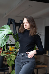 Young beautiful woman posing in a black sweater in the studio