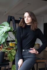 Young beautiful woman posing in a black sweater in the studio