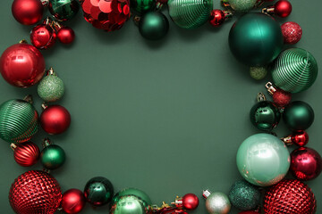 Frame made of different Christmas balls on green background