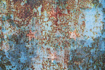 Aged metal surface with peeling light blue paint and heavy rust, evoking a sense of decay,...
