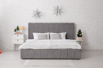 Interior of bedroom with Christmas tree, tables and stars