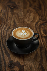 A cup of cappuccino coffee on a wooden table