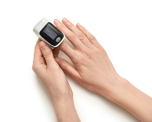 Female hands with pulse oximeter on white background