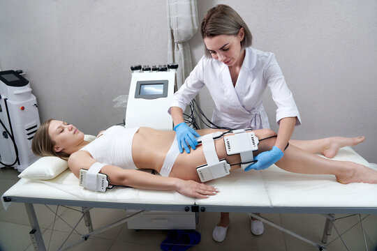 Beautiful woman getting electro stimulation therapy. Laser lipo equipment. Cosmetic fat reduce treatment. Anti cellulite procedure