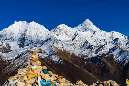 Sacred Mani Stone Stack With Buddhist Prayers At Foot Of Majestic Gongga Snow Mountain Sichuan China - Powered by Adobe