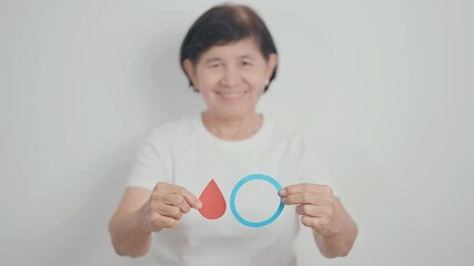 Elderly woman with Blue Circle and red Blood drop for World Diabetes Day, Blue November Health month, Diabetes awareness, Blood sugar check, Insulin, Glucose screening, donation and Health checkup