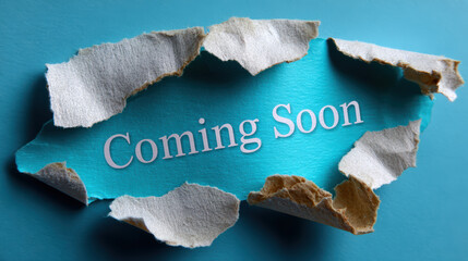 Coming soon message reveal on blue background. Torn white paper shows an exciting announcement for future with ample copy space for text