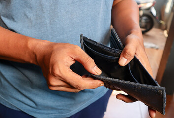 Asian man's hand opens pocket, no money in business wallet, finance and spending concept. 