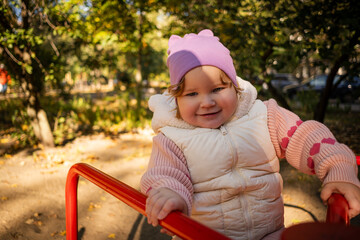 A cheerful child rides on a vibrant carousel in a lively park surrounded by colorful autumn leaves. The sun shines brightly as joyful laughter fills the air.