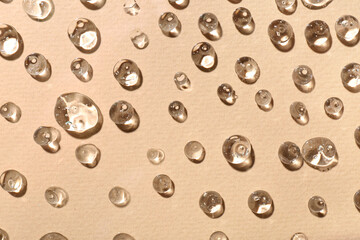 Drops of cosmetic gel on beige background