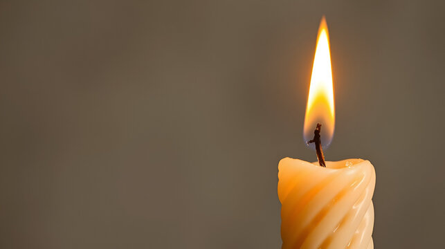 The flickering flame of a Havdalah candle, capturing the braided wax texture with copy space