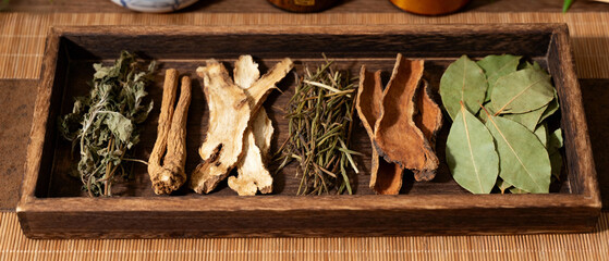 traditional Chinese herbal medicine displayed on wooden tray with dried plants, roots and leaves, natural healing, holistic health, wellness concept, apothecary style.Generated by AI