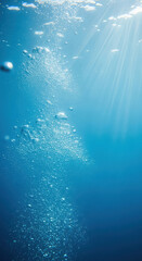 Sunlight filtering through clear blue ocean water with rising bubbles