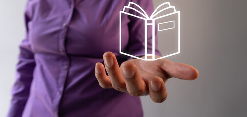 Woman's hand holding a virtual icon of an open book