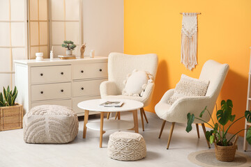 Interior of living room with white soft armchairs near yellow wall