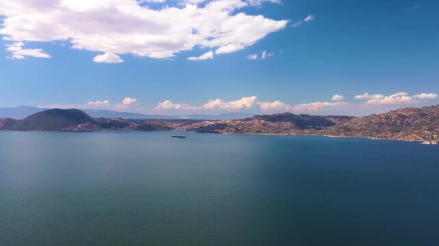 aerial perspective of Bafa Lake in Turkey, showcasing its tranquil waters, surrounding mountains, and the unique landscape shaped by ancient geological processes. This footage captures the natural bea
