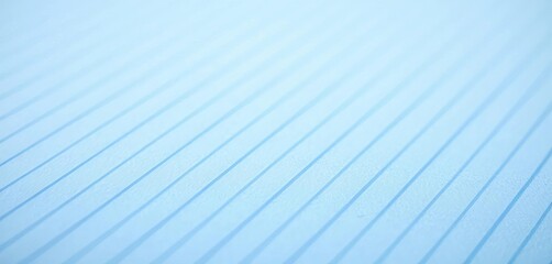 Close-up of a sheet of blue-lined paper, showing the texture and lines, material, desk